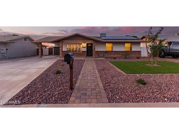 Inviting single-story home featuring solar panels, brick accents and a well-manicured, low maintenance front yard at 126 E Mclellan Rd, Mesa, AZ 85201