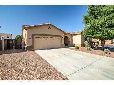 Charming single-story home with a well-manicured lawn, three-car garage, and a cozy entryway at 17985 W Ivy Ln, Surprise, AZ 85388
