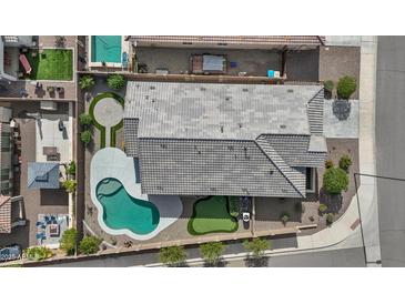 A private backyard with a pool, putting green, and a lush seating area perfect for entertaining at 19203 W Jackson St, Buckeye, AZ 85326