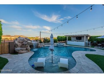 Resort-style pool with a waterfall feature, a swim-up bar, and comfortable lounging area at 22771 N 98Th Dr, Peoria, AZ 85383