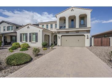 Two-story stucco home featuring a paved driveway, attached two-car garage, and manicured landscaping at 22960 N 94Th Ln, Peoria, AZ 85383