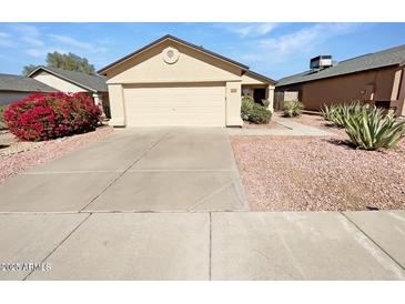Well-maintained single-story home featuring a desert landscape, spacious driveway, and an attached two-car garage at 2906 W Irma Ln, Phoenix, AZ 85027