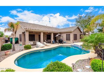 Inviting pool area with covered patio, lounge chairs, and lush landscaping perfect for outdoor relaxation and entertaining at 3519 E Bridgeport Pkwy, Gilbert, AZ 85295