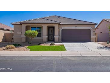 Charming single-story home with desert landscaping, green grass, and a neutral color palette at 42213 W Santa Fe St, Maricopa, AZ 85138