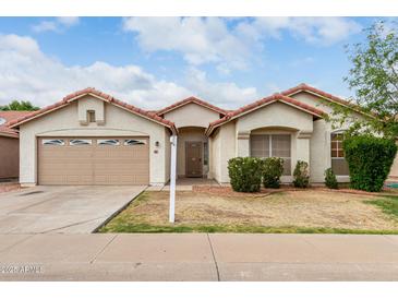 Charming single-story home featuring a well-manicured lawn and a two-car garage with a tile roof at 510 W Amoroso Dr, Gilbert, AZ 85233