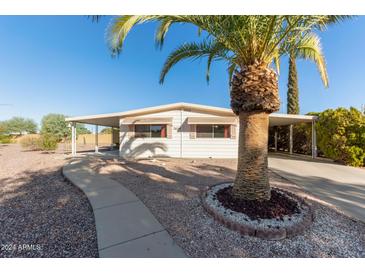 Charming home featuring mature landscaping, sidewalk, and attached carport at 7654 E Calypso Ave, Mesa, AZ 85208