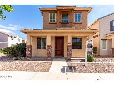 Charming two-story home featuring a cozy front porch and a small balcony on the second floor at 10055 E Isabella Ave, Mesa, AZ 85209