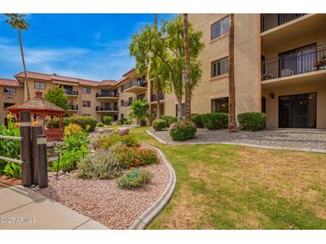 Beautifully landscaped community area with lush flower beds, mature trees and red gazebo at 10330 W Thunderbird W Blvd # B103, Sun City, AZ 85351