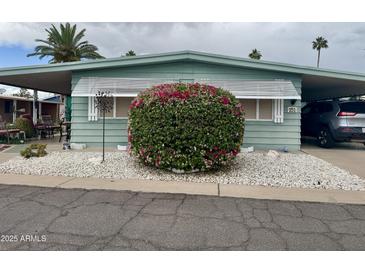Charming mobile home featuring covered parking, well-kept landscaping, and quaint shutters at 120 N Val Vista Dr # 151, Mesa, AZ 85213