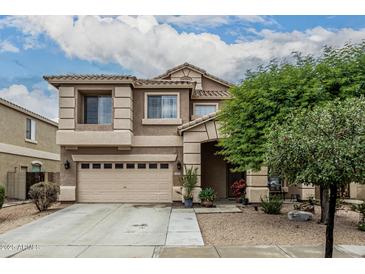 Charming two-story home featuring a well-manicured lawn, a two-car garage, and a welcoming entryway at 14318 N 142Nd Ln, Surprise, AZ 85379