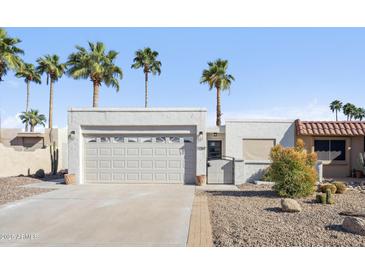 Charming single-story home featuring desert landscaping, palm trees, and a two-car garage at 17019 E Calaveras Ave, Fountain Hills, AZ 85268