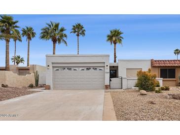 Inviting single-story home featuring a desert landscaped yard and attached two car garage at 17019 E Calaveras Ave, Fountain Hills, AZ 85268