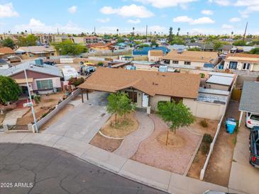 Charming single-story home featuring desert landscaping, a covered carport, and mature trees in a well-maintained neighborhood at 2217 N 51St Ln, Phoenix, AZ 85035