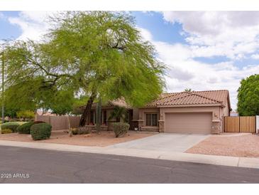 Single-story home with a beige exterior, tile roof, desert landscaping, and mature shade tree in front yard at 345 S Buena Vista Ave, Gilbert, AZ 85296
