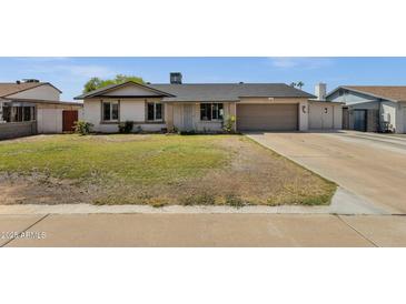 Charming single-story home featuring a well-maintained lawn and an attached two-car garage at 3709 W Grovers Ave, Glendale, AZ 85308