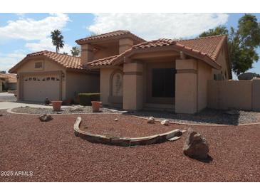 Charming home featuring a tile roof, desert landscaping, and inviting curb appeal at 9203 W Behrend Dr, Peoria, AZ 85382