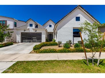 Beautifully landscaped new construction home features a two-car garage and white exterior at 10156 E Talon Ave, Mesa, AZ 85212