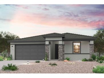 Charming single-story home featuring stone accents, a two-car garage, and a beautifully xeriscaped front yard at 17972 W Camino De Oro --, Surprise, AZ 85387