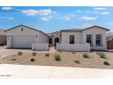 Charming single-story home featuring a stucco exterior, desert landscaping, and a two-car garage at 18883 E Celtic Manor Dr, Queen Creek, AZ 85142