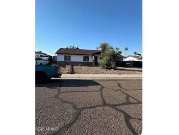Charming single-story home with a well-maintained front yard and a classic design under a clear blue sky at 2926 E Corrine Dr, Phoenix, AZ 85032
