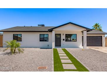 Charming home featuring a modern design, gravel landscaping, and a walkway with artificial turf at 2926 E Corrine Dr, Phoenix, AZ 85032