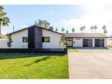 Charming single-story home with a modern design, manicured lawn and spacious driveway at 3502 N Rose Circle Dr, Scottsdale, AZ 85251