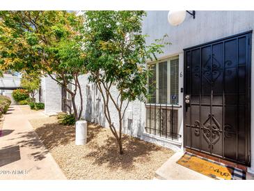 Charming front entrance features a secure black metal gate and a well maintained pebble ground cover at 6348 N 7Th Ave # 6, Phoenix, AZ 85013