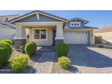 Charming single-story home featuring stone accents, manicured landscaping, and a welcoming paver driveway at 10609 E Durant Dr, Mesa, AZ 85212
