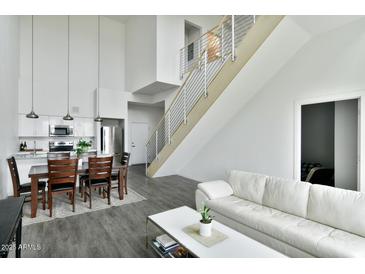 Bright open-concept living space featuring sleek, modern design with hardwood floors, stainless steel railings, and a crisp, white color scheme at 1130 N 2Nd St # 401, Phoenix, AZ 85004