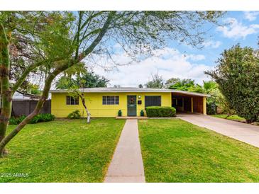 Charming yellow home features a well-maintained front yard, covered parking, and a welcoming entrance at 1609 E Williams N St, Tempe, AZ 85281