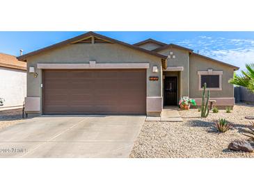 Charming home showcasing a well-manicured desert landscape, complemented by a spacious two-car garage at 1950 E Dust Devil Dr, San Tan Valley, AZ 85143