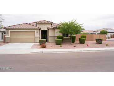 Charming single-story home featuring a terracotta tile roof, a two-car garage, and manicured landscaping at 19814 W Buchanan St, Buckeye, AZ 85326