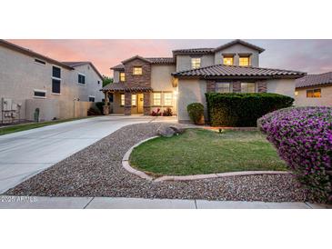 Charming two-story home with a well-manicured lawn, desert landscaping, and a spacious driveway at 21472 E Saddle Ct, Queen Creek, AZ 85142