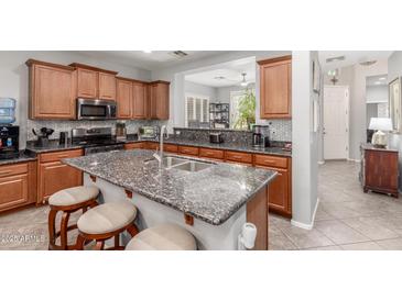 Well-equipped kitchen with a large island, stainless steel appliances, and a breakfast bar with seating for casual dining at 36197 W Cartegna Ln, Maricopa, AZ 85138