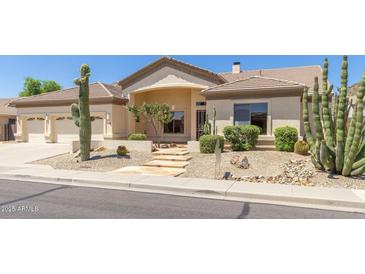 Inviting single-story home featuring desert landscaping with cacti, stone pathway, and beige stucco exterior at 9548 E Grandview St, Mesa, AZ 85207
