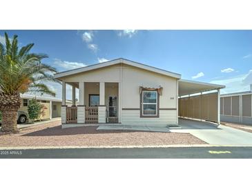 Charming manufactured home with covered porch and carport, featuring a desert landscape at 11596 W Sierra Dawn Blvd # 165, Surprise, AZ 85378