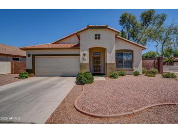 Charming single-story home with a well-maintained front yard and a two-car garage at 15902 W Hearn Rd, Surprise, AZ 85379