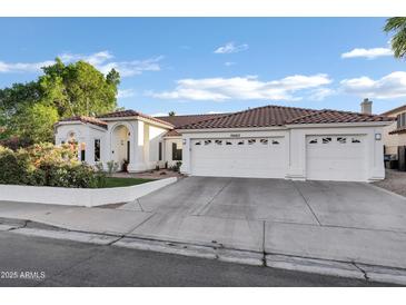 Charming white home with a three-car garage, well-maintained landscaping and a beautiful red tile roof at 16662 S 37Th Way, Phoenix, AZ 85048