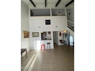 Bright living room featuring high ceilings, clerestory windows, and an open layout to the kitchen area at 1831 W Mulberry Dr # 241, Phoenix, AZ 85015
