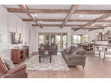 Spacious living room with wood beam ceilings, hardwood floors, and a decorative fireplace at 23126 N 45Th Pl, Phoenix, AZ 85050