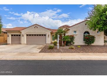 Charming single-story home with a three-car garage, desert landscaping, and a red tile roof at 27105 W Marco Polo Rd, Buckeye, AZ 85396