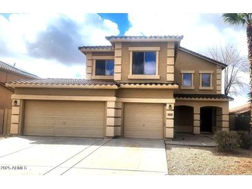 Two-story tan home featuring a spacious three-car garage and well-maintained landscaping at 3057 E Pinto Valley Rd, San Tan Valley, AZ 85143