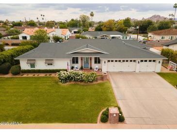 Charming home featuring a well-manicured lawn, three-car garage, and inviting curb appeal at 6311 E Calle Rosa --, Scottsdale, AZ 85251