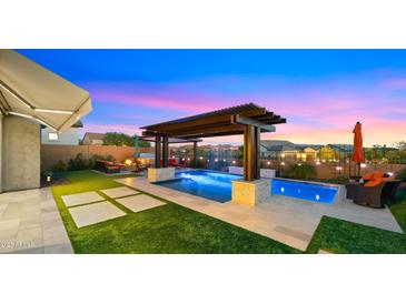 Inviting backyard pool with pergola, travertine deck, and outdoor living space at 8149 E Jaeger St, Mesa, AZ 85207