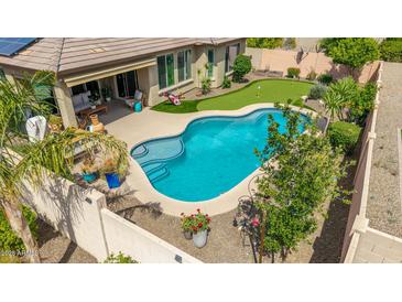 Inviting backyard oasis features a sparkling pool, putting green, and relaxing patio area at 10741 W Paso Trl, Peoria, AZ 85383