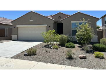 Charming single-story home with a well-maintained front yard and a two-car garage at 10743 W Bronco Trl, Peoria, AZ 85383