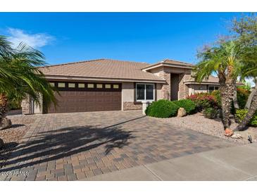 Charming single-story home featuring a tile roof, brick driveway, desert landscaping, and a two-car garage at 11342 E Laguna Azul Cir, Mesa, AZ 85209