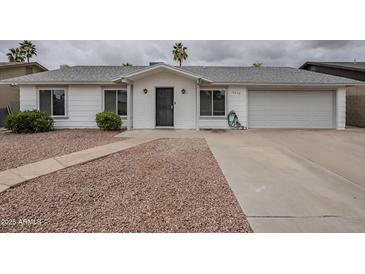 Charming single-story home with a well-maintained front yard and an attached two-car garage at 12228 S Pewaukee St, Phoenix, AZ 85044