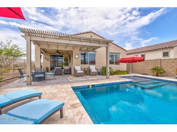 Backyard oasis featuring a pool, lounge chairs, outdoor seating, and a covered patio at 16139 S 178Th Dr, Goodyear, AZ 85338