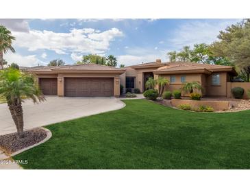 Beautiful home with a well-manicured lawn and a three-car garage at 844 E County Down Dr, Chandler, AZ 85249